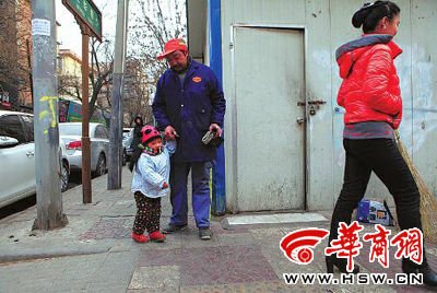 由于没人照看,爸爸妈妈干活时带着两岁多的小韩灵 本报记者 董国梁 摄